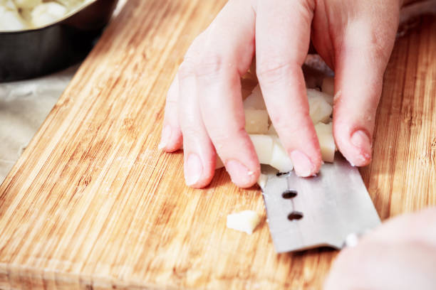 istock Woman's hand with a knife cutting the boiling potatoes 947845532