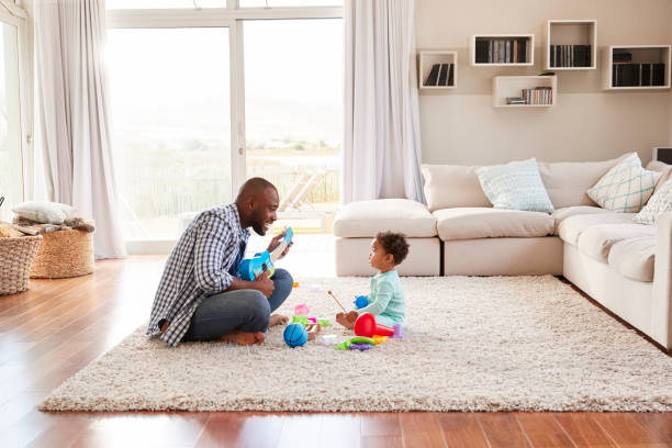 istock Black father and toddler son playing in sitting room 947848334