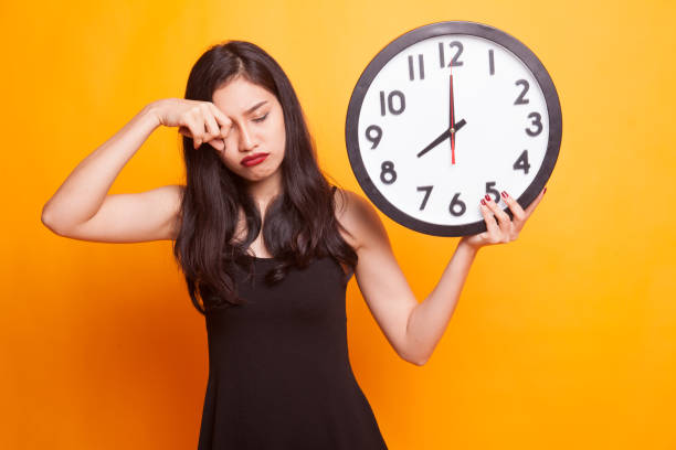istock Young Asian woman with a clock. 947849190