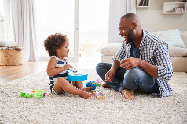 istock Dad and toddler daughter playing instruments in sitting room 947849436