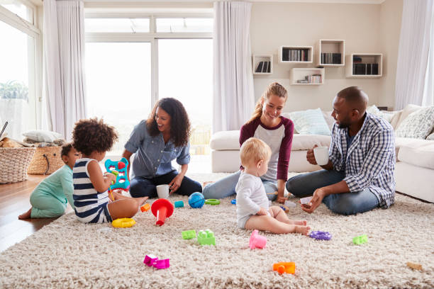 istock Three friends playing with toddlers on sitting room floor 947850292