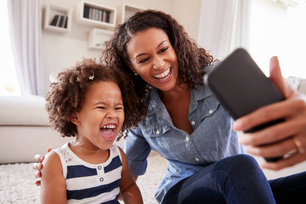 giovane madre e figlia bambina che si fanno selfie a casa - domestic life mother baby multi ethnic group foto e immagini stock