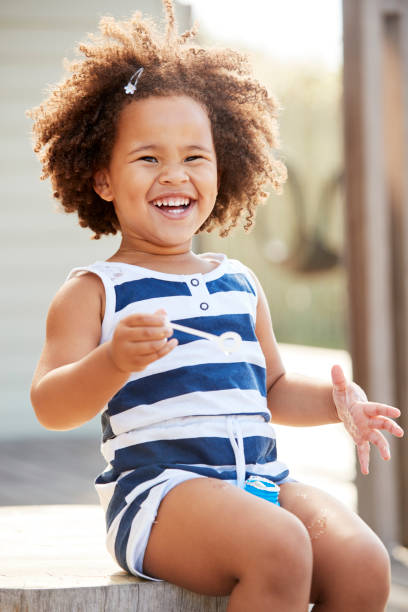 istock Young black girl blowing bubbles outside her home 947853710