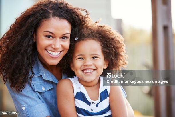Mixed Race Mother And Young Daughter Smile To Camera Outside Stock Photo - Download Image Now
