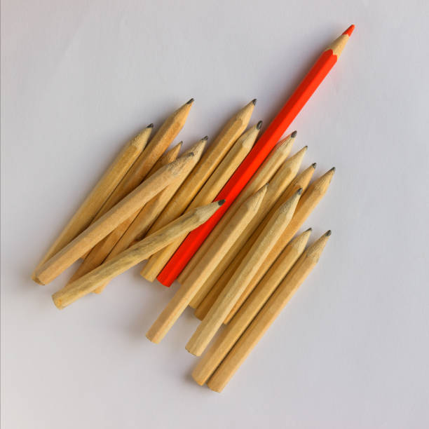 istock Red pencil standing out from crowd of plenty identical  pencils on table. Leadership, uniqueness, independence, initiative, strategy, dissent, think different, business success concept. 947854350