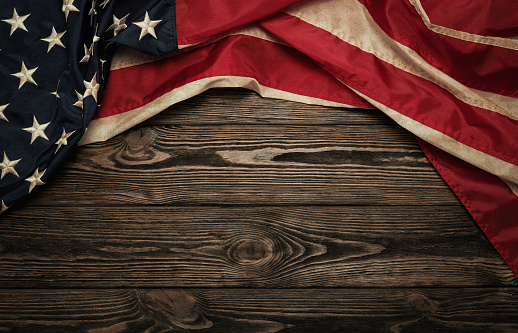 Old USA flag on wooden background with copy space