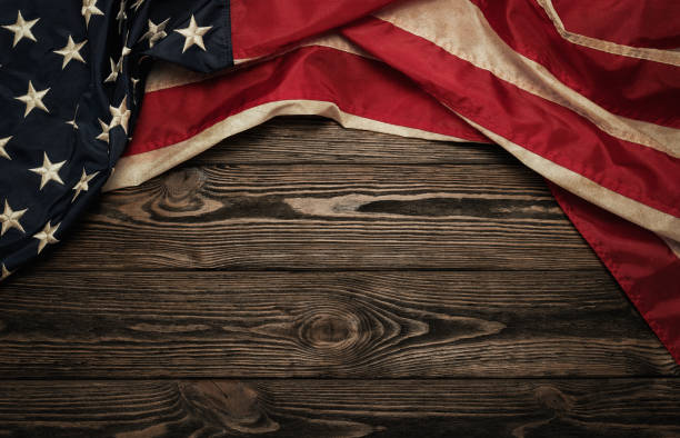 Old american flag Old USA flag on wooden background with copy space vintage american flag stock pictures, royalty-free photos & images