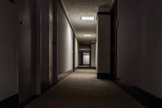 Looking down a hallway in an office building Looking down a hallway in an office building with low lights low lighting stock pictures, royalty-free photos & images