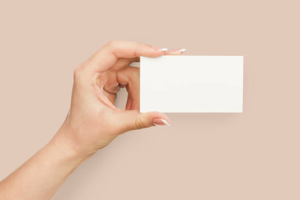 istock Female hand holding blank plastic card isolated on pink 947870276