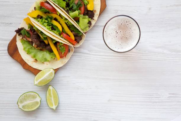 Beef tacos with salad, tomato and beer. Copy space. From above.
