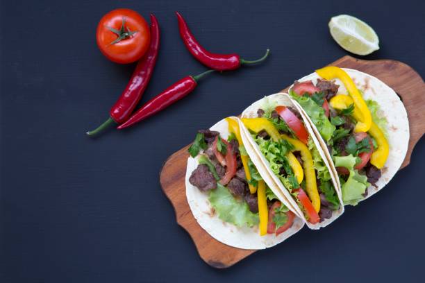 istock Corn tortillas with grilled beef on dark background. Top view. 947874214