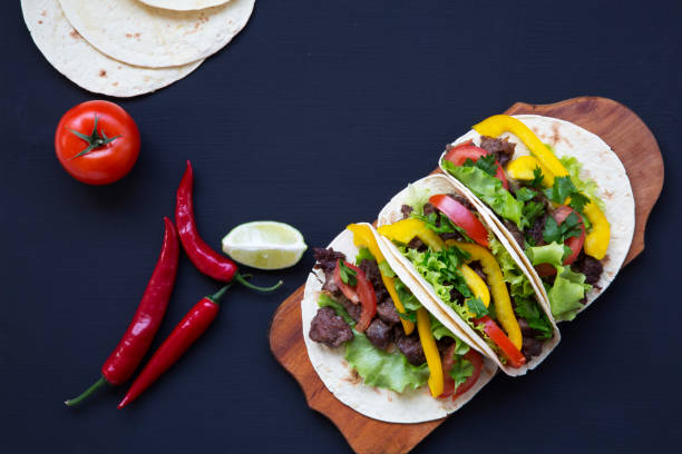 istock Corn tortillas with grilled beef on dark background. Top view. Copy space. 947874276