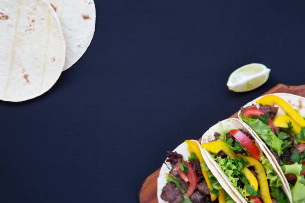 istock Mexican street tacos flat lay composition with beef and vegetables. Flat top view. 947874322