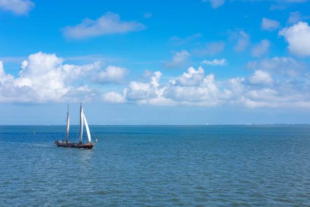 Classic sailing ship on the Waddensea during a beautiful day in summer. The islands of Vlieland and Terschelling lie on the horizon in the distance.