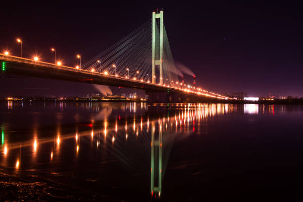 istock Night city. Beautiful glowing bridge over the river 947875094