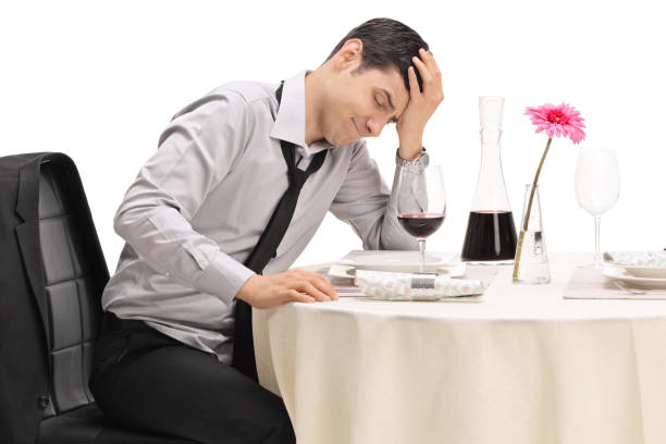 istock Stood up guy sitting at a restaurant table and holding his head in disbelief 947890662