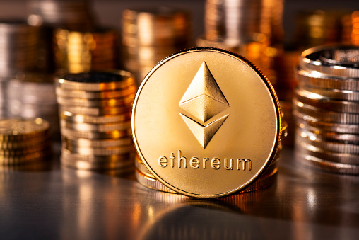 Frankfurt, Hesse, Germany - April 12, 2018: Cryptocurrency coin Ethereum with several stacks of coins in the background