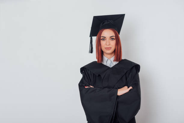 istock Graduate student wearing graduation gown with her hands clasped 947895982