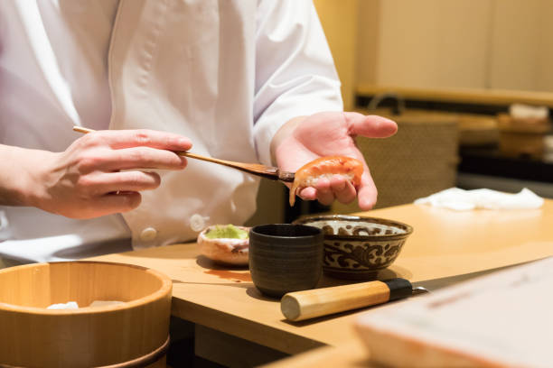 Chef cook making sushi Sashimi with sharp knife on the cutting board, Omakase style Japanese fine dining concept