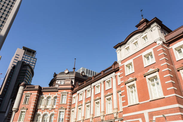 the classic architecture of the tokyo train station contrasts with modern office building in the buisiness district of marunouchi in tokyo - tokyo station railroad station chiyoda ward building exterior imagens e fotografias de stock