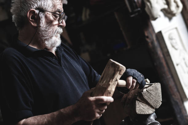 istock Senior man working on his wooden sculpture in his workshop. 947948214