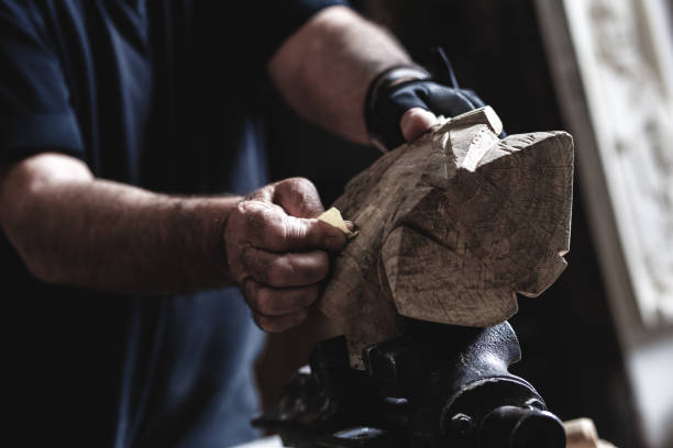 istock Senior man working on his wooden sculpture in his workshop. 947948400