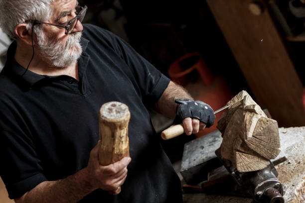 istock Senior man working on his wooden sculpture in his workshop. 947948410