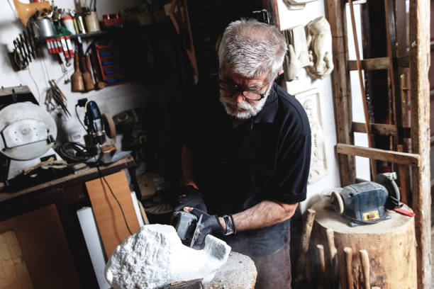 istock Senior man working on marble sculpture in his workshop. 947948882