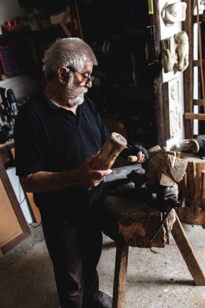istock Senior man working on his wooden sculpture in his workshop. 947951104
