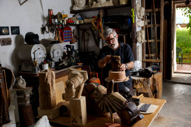 istock Senior sculptor working on his clay sculpture in his workshop. 947952486