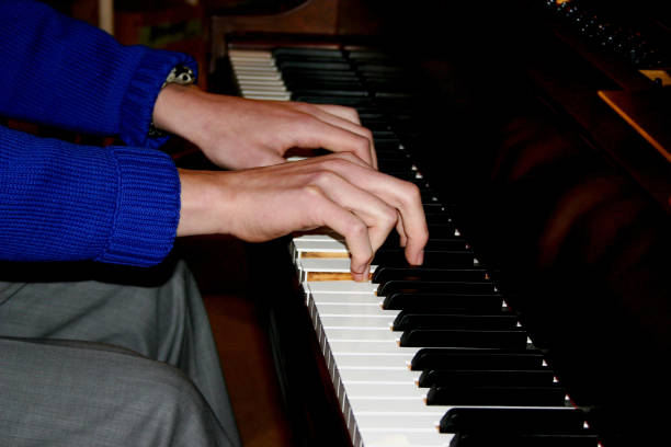 istock Male hands playing piano closeup. 947956372