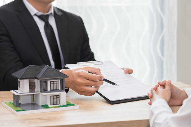 istock Businessman pointing the place where should sign documrnt for making contract with customer. 947959000