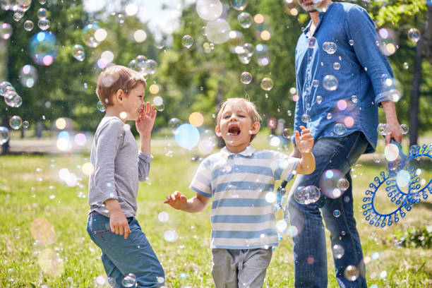 funny little boy avec des bulles de savon - bubble child bubble wand blowing photos et images de collection