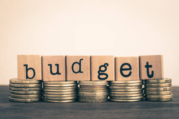 istock The word Budget on currency, gold coins stack. 947959812