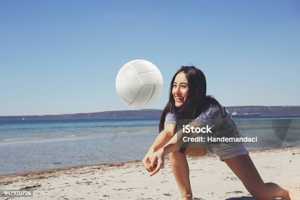 One Young Beautiful Lady Is Playing Volleyball On The Beach Stock Photo - Download Image Now