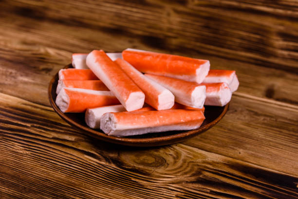 istock Ceramic plate with crab sticks on wooden table 947972262