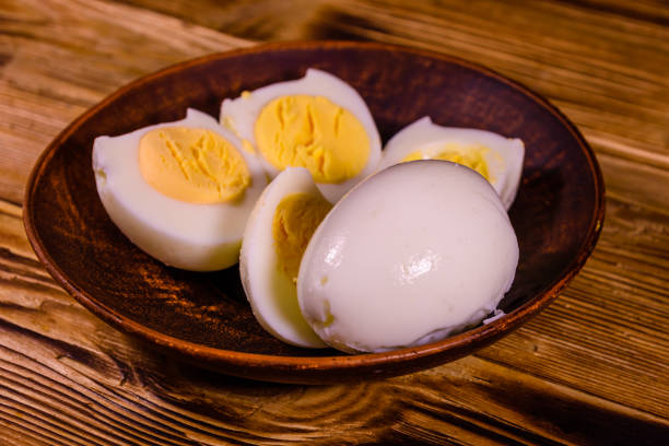 istock Ceramic plate with peeled boiled eggs on wooden table 947972316