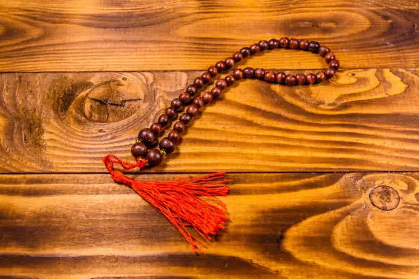Photo of Brown rosary on the wooden table. Top view