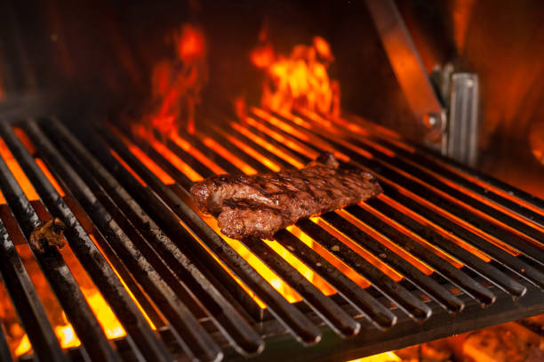 istock cooking steaks on a grill with fire. shot with selective focus 947982644