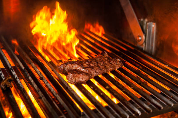 istock cooking steaks on a grill with fire. shot with selective focus 947982808