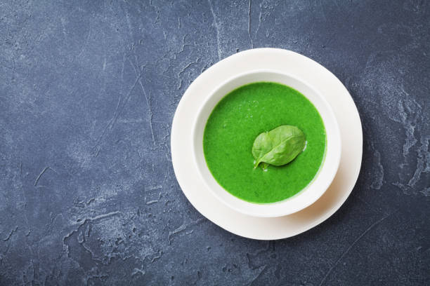 istock Green spinach soup in bowl on black table top view. 947984256