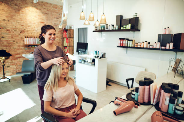 jeune femme parle avec son coiffeur lors d’un rendez-vous de salon - coiffeur photos et images de collection