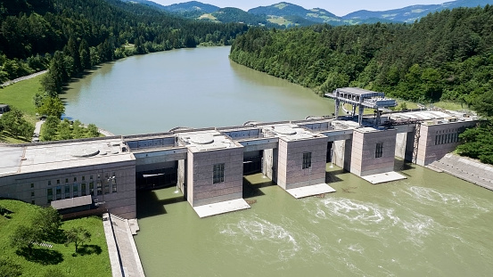 Aerial view of Vuzenica hydroelectric power plant on Drava River, mountains in background.