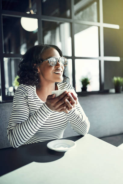 istock Young African woman sitting at a cafe table drinking coffee 948003818