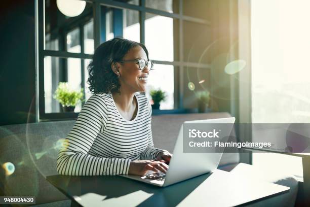 Smiling Young African Woman Working Online With Her Laptop Stock Photo - Download Image Now