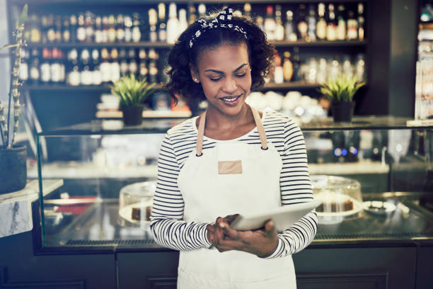 istock Smiling African entrepreneur working in her cafe with a tablet 948005650