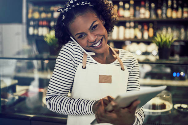 istock Smiling African entrepreneur talking on the phone in her cafe 948005840