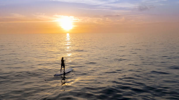 istock Woman doing standup paddling in sea 948010736