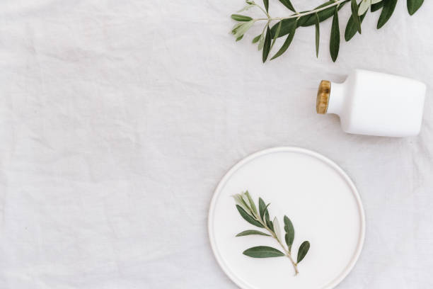 Flat lay mock up with olive branch over linen. Minimal eco concept