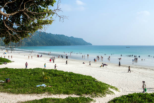 Indian tourists a large crowd resting on the most beautiful beach in Asia Indian tourists a large crowd resting on the most beautiful beach in Asia called Radhanagar Beach, Havelock, Andaman Islands, India. 18 January 2018 andaman sea stock pictures, royalty-free photos & images
